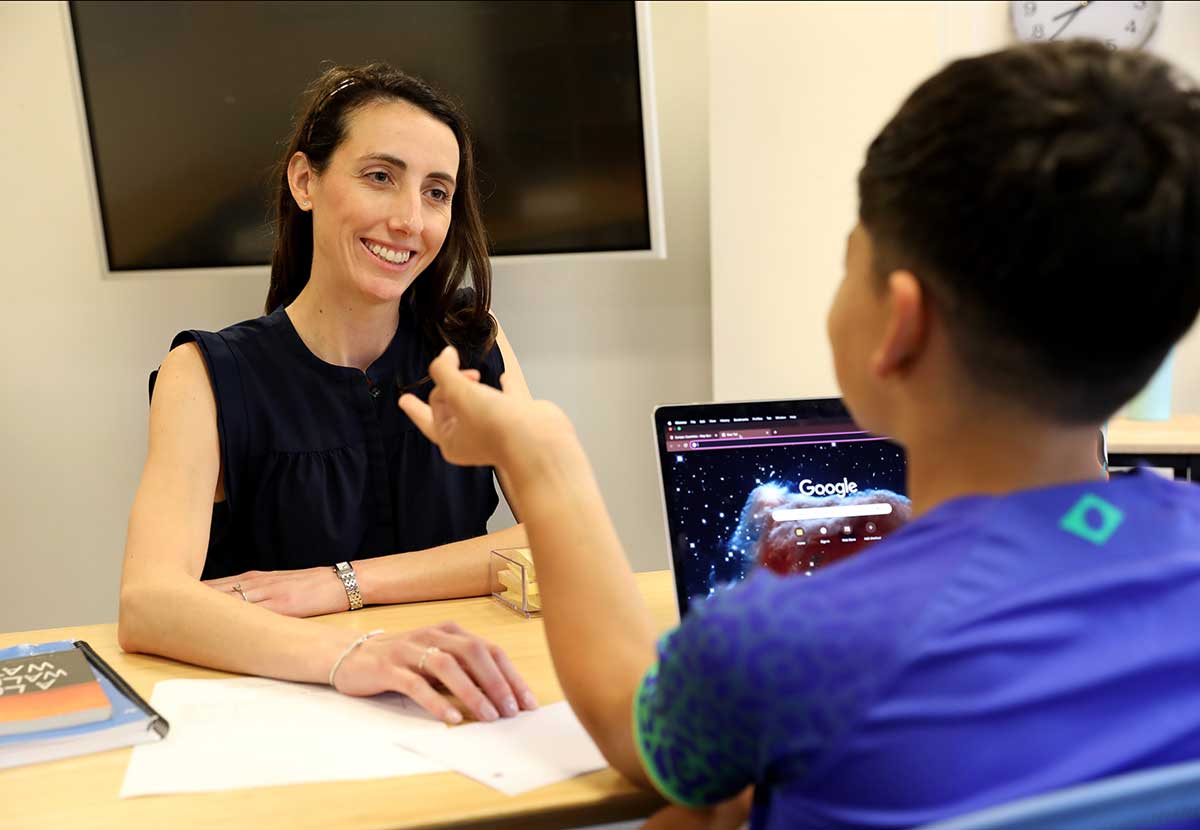 The middle school learning specialist talks with a student